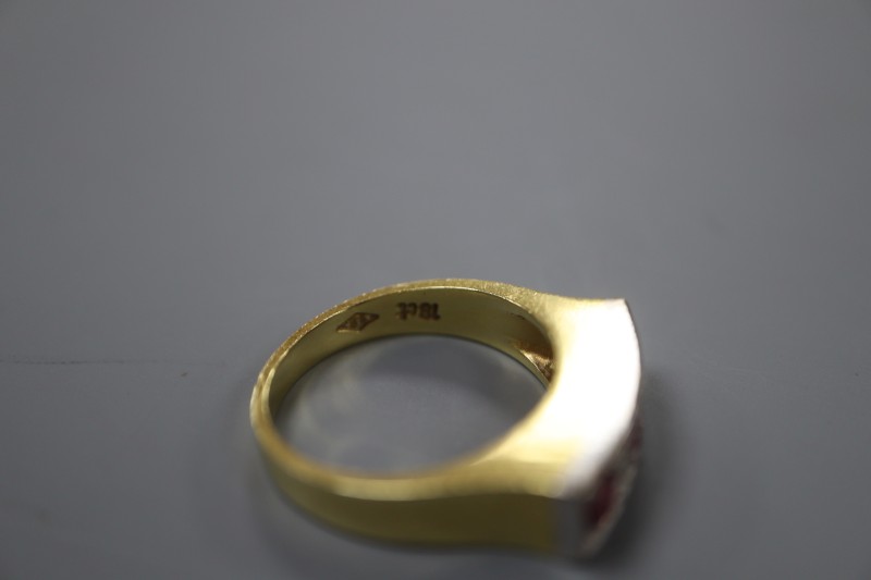 A modern 18ct yellow metal, three stone ruby and four stone diamond half hoop ring, size O, gross weight 7.4 grams.